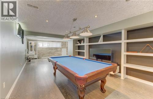 Finished lower level featuring wood-finish flooring, recessed lighting, and a built-in shelving unit - 106 Autumn Hill Crescent, Kitchener, ON - Indoor Photo Showing Other Room