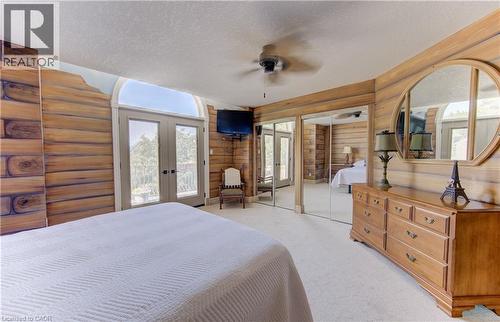 Interior space featuring wood-finish wall paneling, a ceiling fan, and light-colored carpet flooring - 74 Forest Edge Trail, Kitchener, ON 