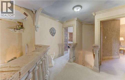 Hallway featuring textured walls, stone balusters, decorative ceiling accents, and arched entryways - 74 Forest Edge Trail, Kitchener, ON 