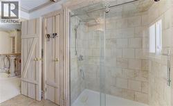 Glass-enclosed shower featuring subway tile surround, polished chrome fixtures, and a sliding door - 