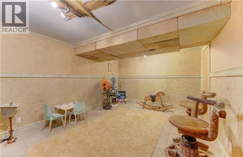Lower level room featuring textured walls, crown molding, recessed lighting, tile flooring, and a decorative ceiling fixture - 74 Forest Edge Trail, Kitchener, ON 