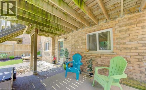 Covered patio area featuring a flagstone surface and a light brick exterior wall - 74 Forest Edge Trail, Kitchener, ON 