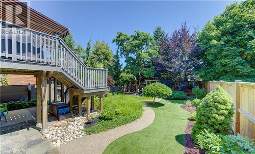 Multi-level wooden deck with staircase leading to a paver patio - 74 Forest Edge Trail, Kitchener, ON 