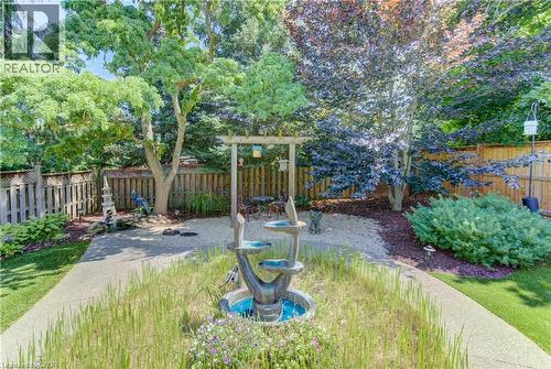 Expansive backyard oasis featuring mature landscaping, manicured lawn, and established trees providing natural privacy - 74 Forest Edge Trail, Kitchener, ON 
