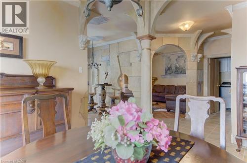 Dining area featuring arched doorways, stone wall accents, and an overhead light fixture - 74 Forest Edge Trail, Kitchener, ON 