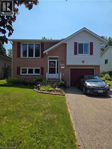 Welcoming brick and siding facade featuring a two-story split-level design with a covered entry, multi-pane windows with burgundy shutters, and an attached two-car garage - 295 White Rock Crescent, Waterloo, ON - Outdoor