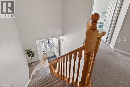 Split-level entry with wood-finish balusters and newel post, carpeted stairs, and a tile-floor foyer - 10 Cadham Boulevard Unit# 29, Hamilton, ON - Indoor Photo Showing Other Room