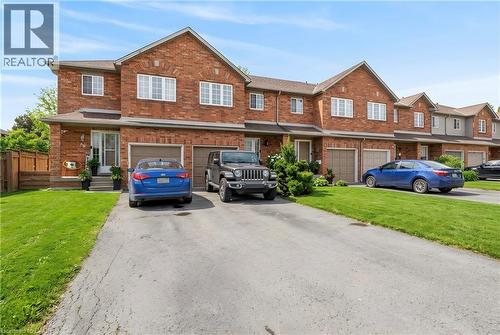 Brick exterior with a gabled roofline, single-car garage, and an asphalt driveway - 10 Cadham Boulevard Unit# 29, Hamilton, ON - Outdoor With Facade