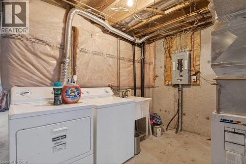 Utility space featuring exposed ceiling joists, concrete flooring, a utility sink, and an electrical panel - 10 Cadham Boulevard Unit# 29, Hamilton, ON - Indoor