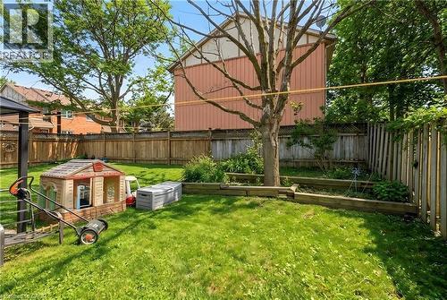 Expansive backyard featuring a manicured lawn, mature trees, and wood fencing - 10 Cadham Boulevard Unit# 29, Hamilton, ON - Outdoor With Backyard