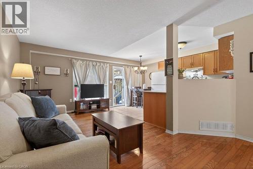Hardwood flooring, kitchen pass-through, rear patio access, recessed lighting, and ceiling light fixture - 10 Cadham Boulevard Unit# 29, Hamilton, ON - Indoor Photo Showing Living Room