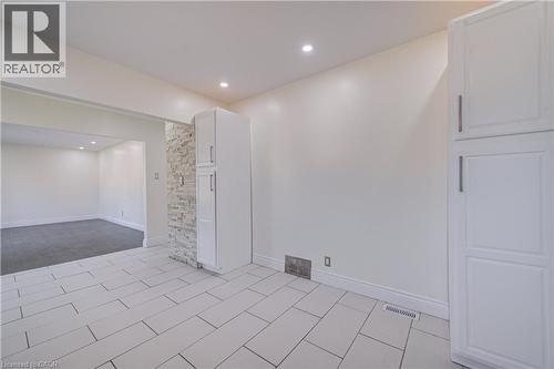 White rectangular tile flooring, recessed ceiling lighting, light-toned walls, and built-in cabinetry with silver-tone hardware - 161 Kipling Avenue, Kitchener, ON - Indoor Photo Showing Other Room