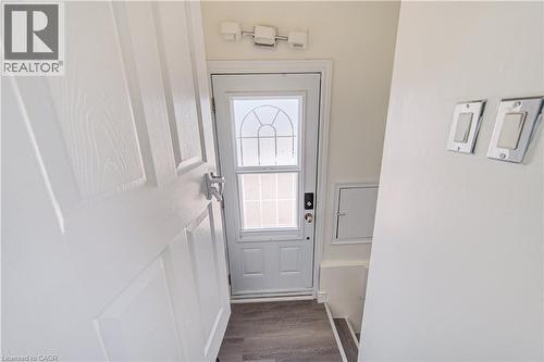 White paneled door with chrome hardware, glass-paneled entry door, wood-finish flooring, and recessed wall paneling - 161 Kipling Avenue, Kitchener, ON - Indoor Photo Showing Other Room