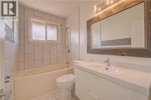 White vanity with integrated sink, chrome faucet, and rectangular mirror with a wood-finish frame - 161 Kipling Avenue, Kitchener, ON - Indoor Photo Showing Bathroom