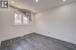 Recessed ceiling lighting, wood-finish flooring, and white walls - 