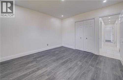 Wood-finish flooring with white wall finishes, recessed lighting, and a bi-fold closet - 161 Kipling Avenue, Kitchener, ON - Indoor Photo Showing Other Room