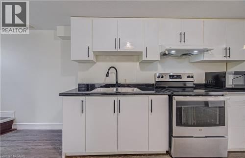 Kitchen featuring white cabinetry, dark countertops, a stainless steel electric range, and a matte black gooseneck faucet - 161 Kipling Avenue, Kitchener, ON - Indoor Photo Showing Kitchen With Double Sink