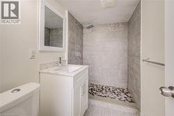Vanity with a white finish, stone-finish countertop, and undermount sink - 