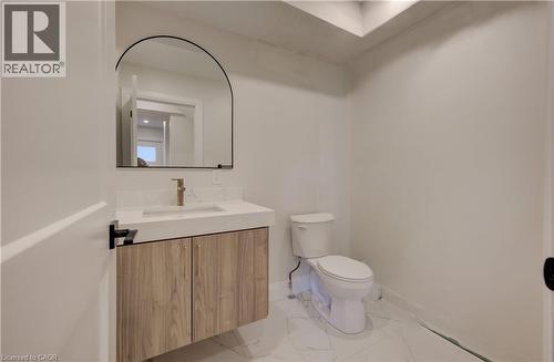 Floating vanity with wood-finish cabinetry, integrated sink, and gold-tone faucet - 34 Moore Avenue N, Waterloo, ON - Indoor Photo Showing Bathroom