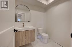 Floating vanity with wood-finish cabinetry, integrated sink, and gold-tone faucet - 