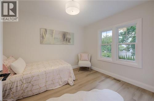 Light-toned wood-finish flooring, white walls, and a contemporary ceiling light fixture - 34 Moore Avenue N, Waterloo, ON - Indoor Photo Showing Bedroom