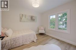 Light-toned wood-finish flooring, white walls, and a contemporary ceiling light fixture - 