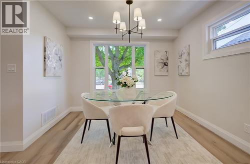 Recessed lighting, wood-finish flooring, white trim, and a multi-light chandelier - 34 Moore Avenue N, Waterloo, ON - Indoor Photo Showing Dining Room