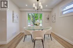 Recessed lighting, wood-finish flooring, white trim, and a multi-light chandelier - 