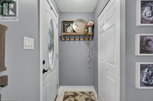 White paneled entry door with an oval decorative glass insert and black hardware - 60 Elford Crescent, Hamilton, ON - Indoor Photo Showing Other Room