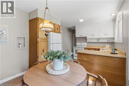 Bright dining area featuring a round wood-finish table paired with a pendant light fixture overhead - 974 Unsworth Avenue, Burlington, ON 