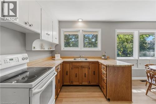 Chef's kitchen featuring warm wood cabinetry with ample storage, butcher-block countertops, stainless steel appliances, and a generous center island with seating - 974 Unsworth Avenue, Burlington, ON 