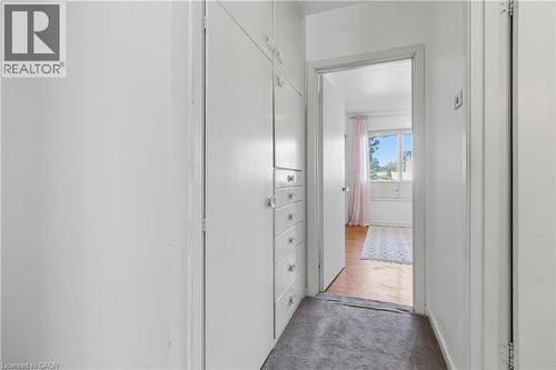 Bright hallway with white painted walls, built-in cabinetry with multiple drawers for ample storage, and wood-finish flooring - 974 Unsworth Avenue, Burlington, ON 