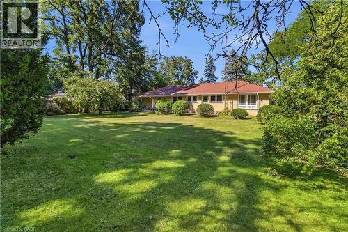 Expansive manicured lawn framed by mature trees and lush landscaping - 974 Unsworth Avenue, Burlington, ON 