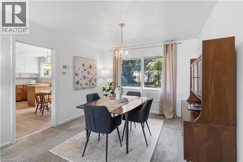 Dining area featuring a modern chandelier, large window, and light-toned wall paint - 974 Unsworth Avenue, Burlington, ON 