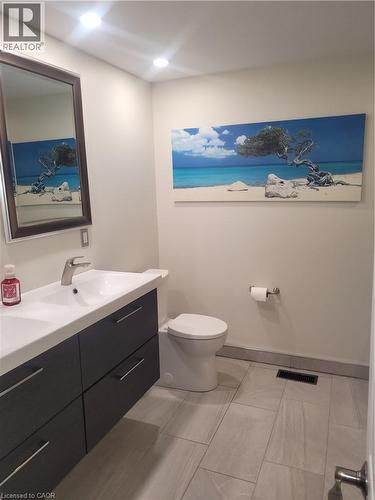 Modern bathroom featuring a floating vanity with a white integrated sink, chrome faucet, and rectangular mirror - 23 Bentley Place, Hamilton, ON - Indoor Photo Showing Bathroom