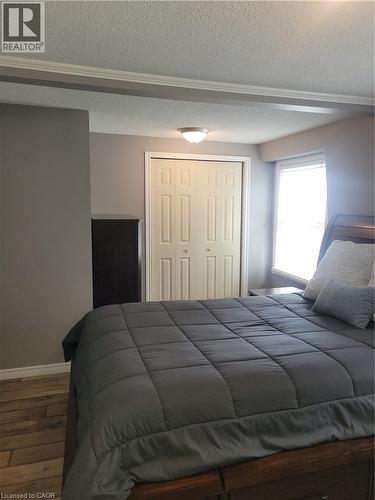 Bedroom featuring wood-finish flooring, neutral wall tones, and white trim - 23 Bentley Place, Hamilton, ON - Indoor Photo Showing Bedroom