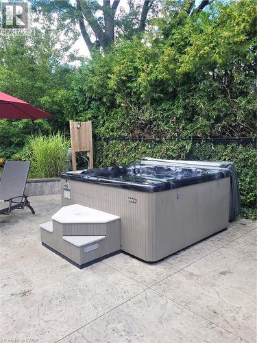 Outdoor spa featuring a textured beige exterior and a dark cover - 23 Bentley Place, Hamilton, ON - Outdoor