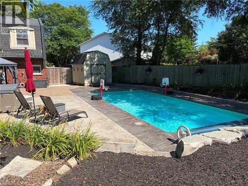 Rectangular swimming pool with a stone coping and a concrete surround - 23 Bentley Place, Hamilton, ON - Outdoor With In Ground Pool With Backyard