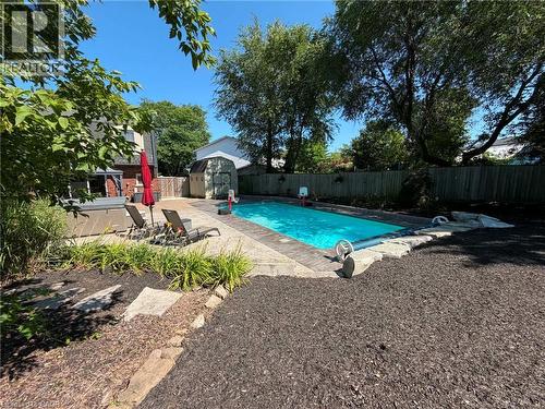 Expansive outdoor living space featuring a rectangular in-ground swimming pool, a hot tub, and a stone paver patio - 23 Bentley Place, Hamilton, ON - Outdoor With In Ground Pool With Backyard