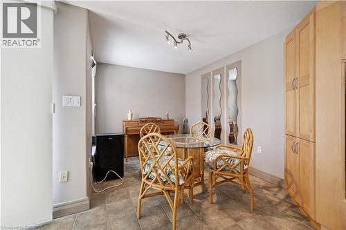 Bright dining area showcasing natural light, wood-finish flooring, and woven rattan dining chairs - 36 Hayhurst Road Unit# 329, Brantford, ON - Indoor Photo Showing Dining Room