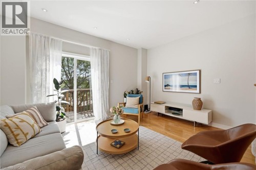 Living area featuring wood-finish flooring, recessed lighting, and a sliding glass door opening to an outdoor space - 678 Rowley Common, Burlington, ON - Indoor Photo Showing Living Room