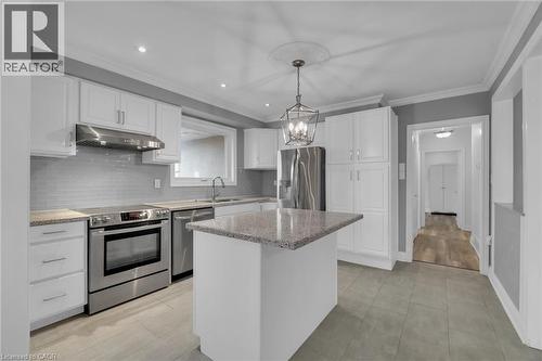 Kitchen featuring a central island with a granite-style countertop, white cabinetry, stainless steel appliances, and a tiled backsplash - 197 Troy Street, Mississauga, ON - Indoor Photo Showing Kitchen With Upgraded Kitchen
