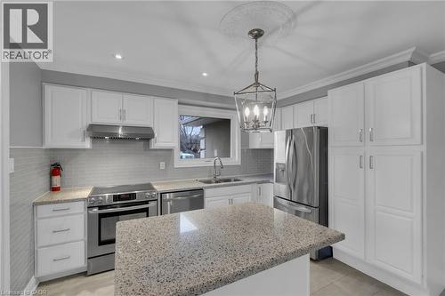 Kitchen featuring white cabinetry, light gray tile backsplash, recessed lighting, and a central island with a speckled countertop - 197 Troy Street, Mississauga, ON - Indoor Photo Showing Kitchen With Double Sink With Upgraded Kitchen