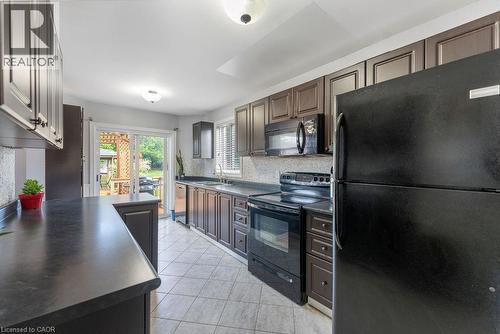 Kitchen featuring dark cabinetry, dark countertops, and tile flooring - 33 Remple Court, Cambridge, ON - Indoor Photo Showing Kitchen