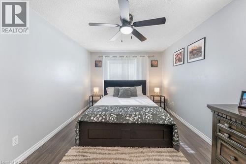 Room featuring wood-finish flooring, a window with horizontal blinds, and a ceiling fan with integrated lighting - 33 Remple Court, Cambridge, ON - Indoor Photo Showing Bedroom