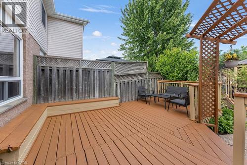 Expansive outdoor deck featuring wood-finish flooring, built-in perimeter seating, and a decorative wood trellis - 33 Remple Court, Cambridge, ON - Outdoor With Deck Patio Veranda With Exterior