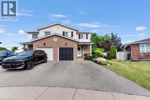 Two-story residence featuring brick and siding exterior, a two-car garage with both panel and carriage-style doors, and a paved driveway - 33 Remple Court, Cambridge, ON - Outdoor With Facade