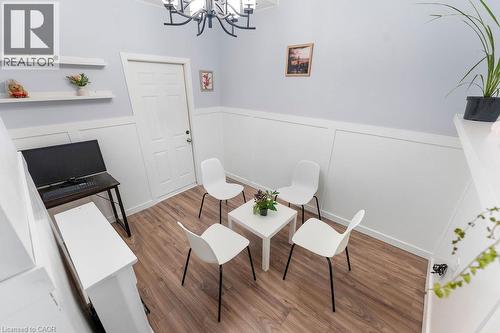 Room featuring wood-finish flooring, white wainscoting, and a white panel door - 33 Remple Court, Cambridge, ON - Indoor