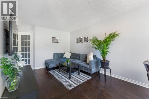 Living area featuring dark wood-finish flooring, light grey painted walls, and white baseboards - 33 Remple Court, Cambridge, ON - Indoor Photo Showing Living Room