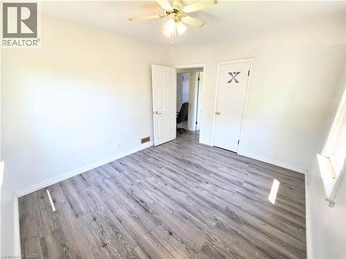 Wood-finish flooring, white walls, white trim, ceiling fan, and window - 353 East 21St Street, Hamilton, ON - Indoor Photo Showing Other Room